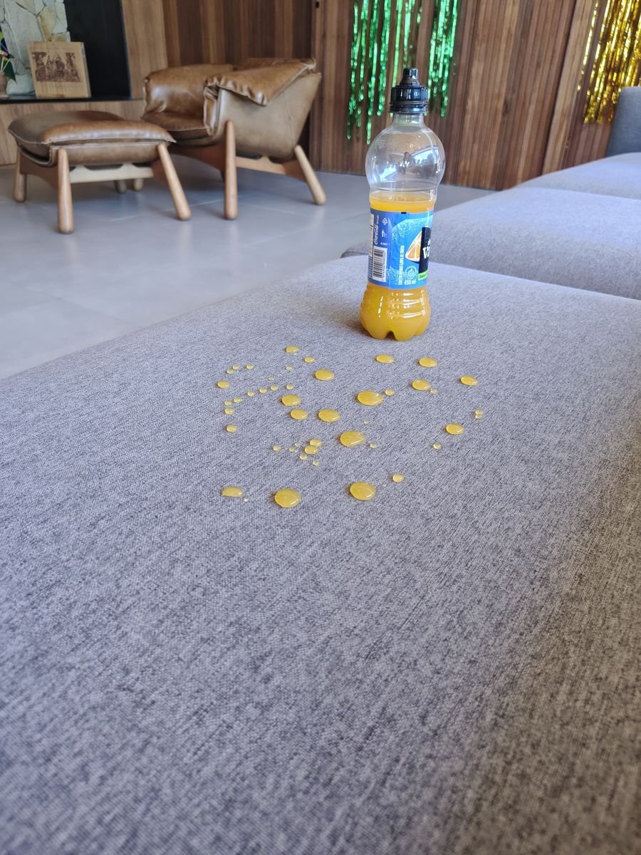 Gotas de suco repelidas pelo tecido de sofá tratado pela Inove